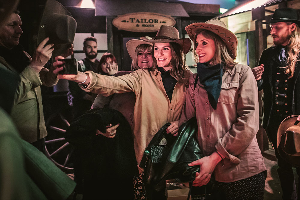Must-try immersive experiences in London - Moonshine Saloon Must-try immersive experiences in London - Moonshine Saloon - group of friends wearing cowgirl outfits taking a Selfie