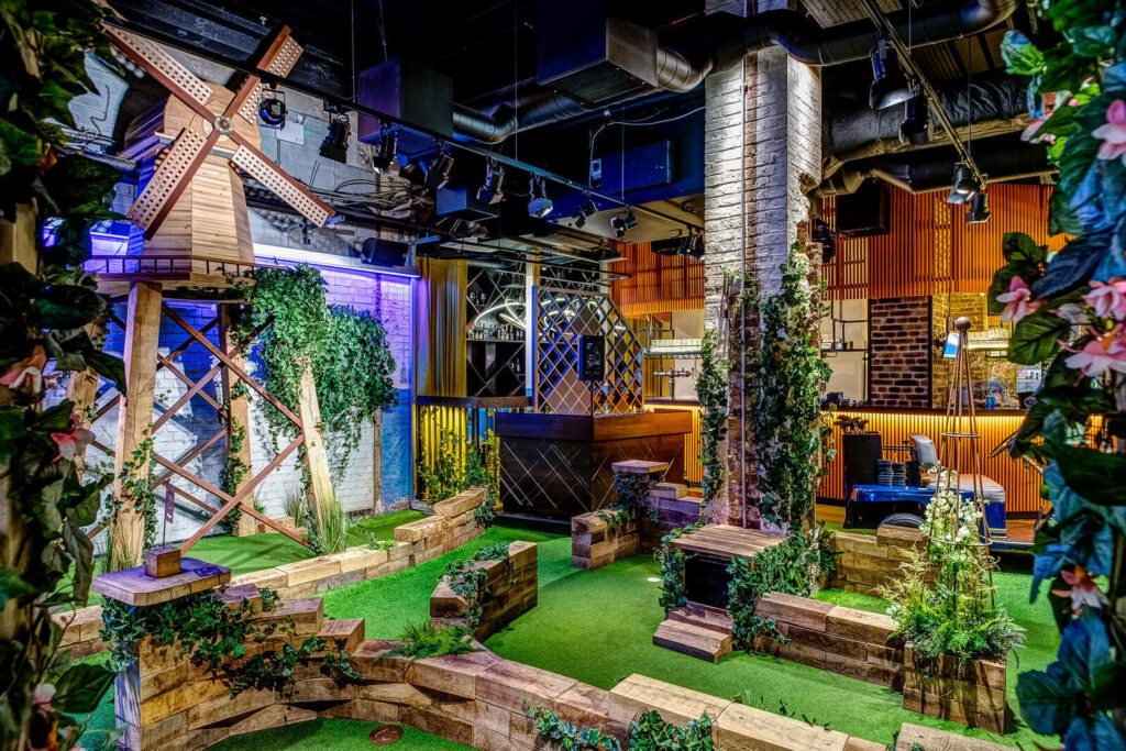 9 Best Brunch Spots in the City of London - Swingers City 9 Best Brunch Spots in the City of London - Swingers City - indoors crazy golf course, fake ivy running along the course walls and a windmill on a stand in the backgorund