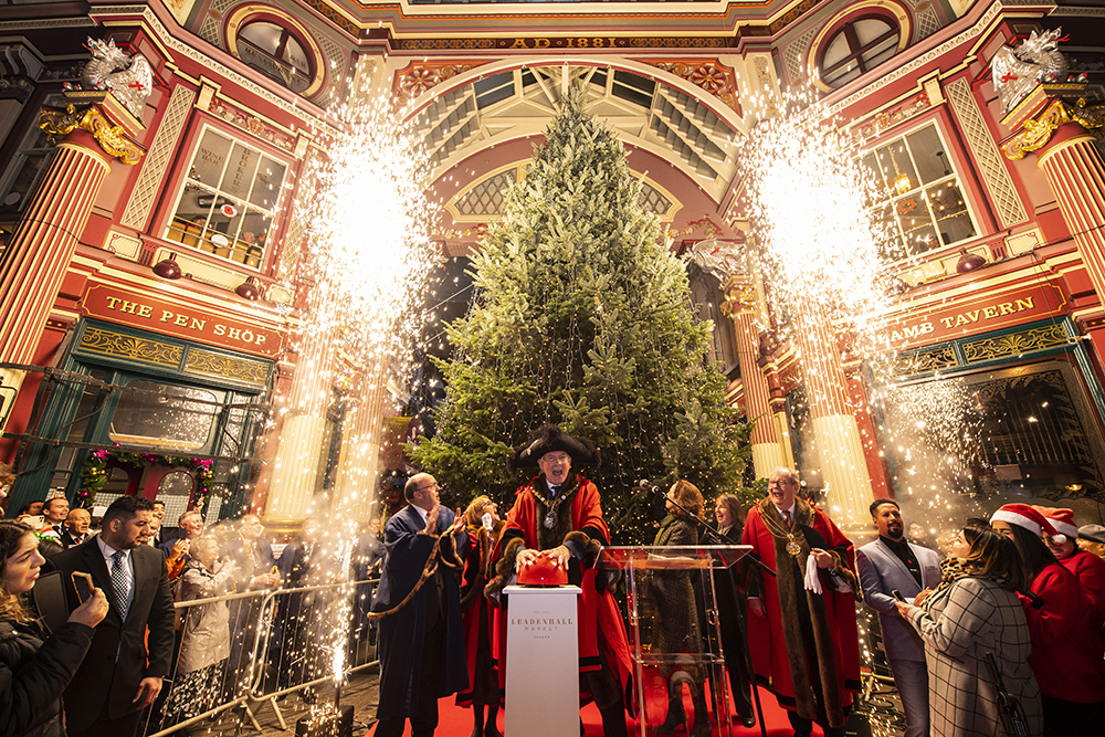 Lord Mayor switching on the lights of a big Christmas tree at a Victorian market with fireworks on each side