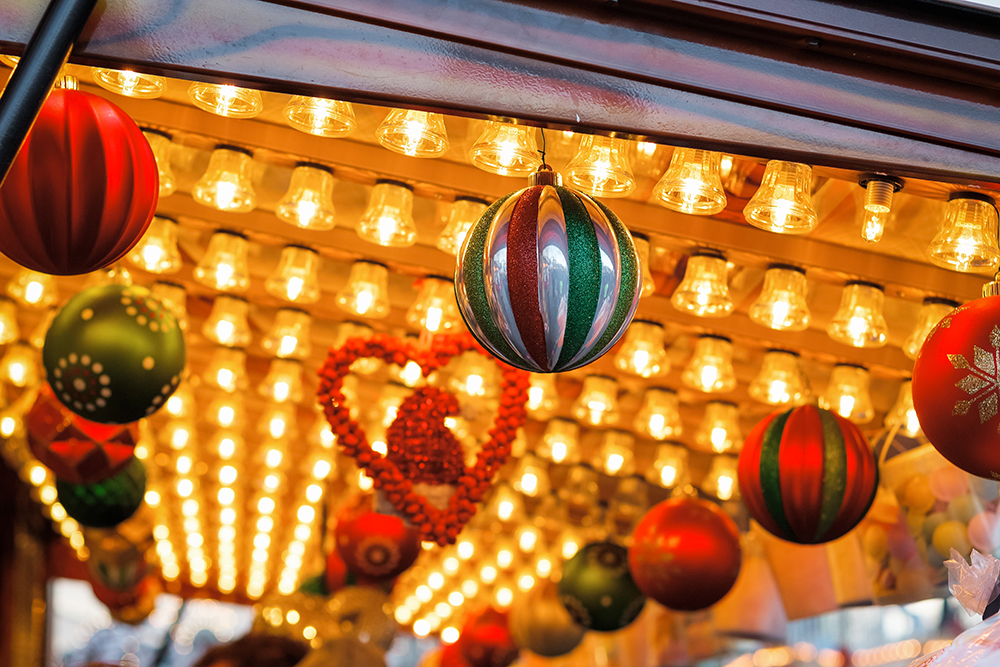 Colourful Christmas baubles hanging from an illuminated ceiling