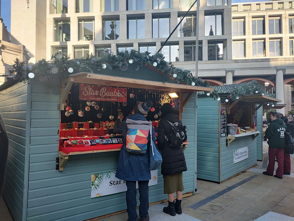 couple looking at a Christmas decorated market stall