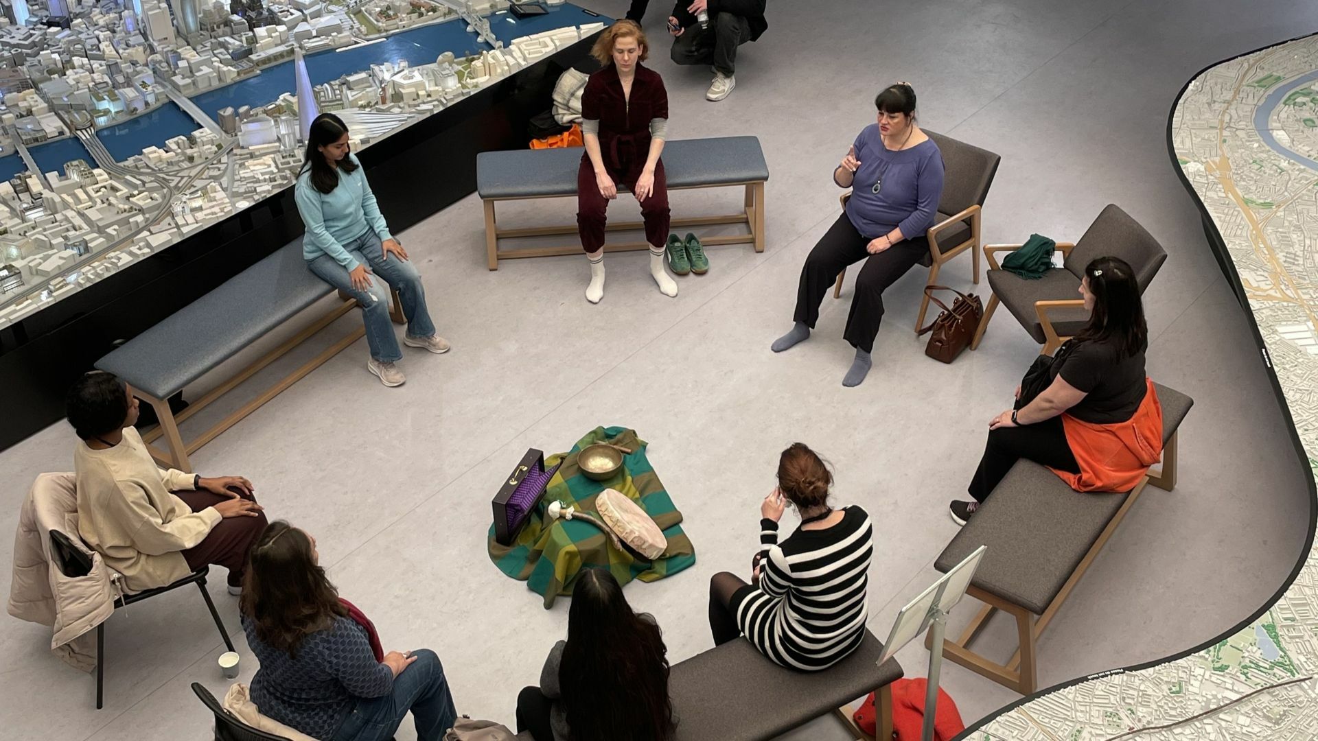 A group of bowl sitting in chairs and practicing singing during a sound bowl session