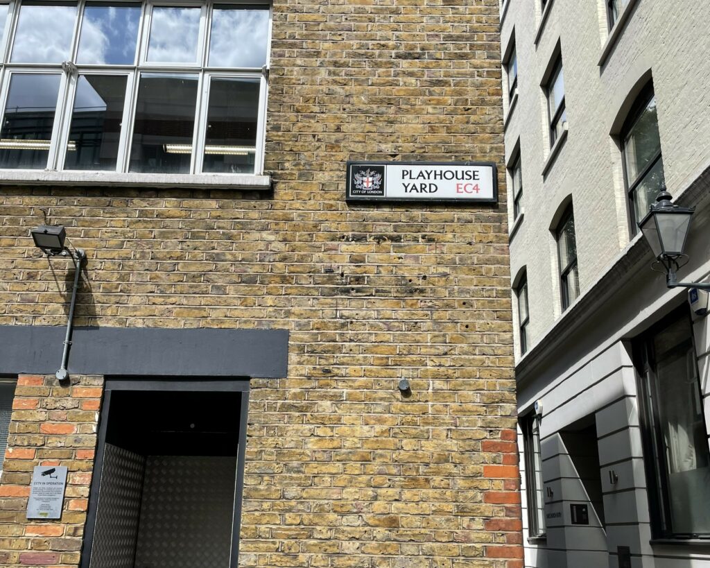 Brick building with sign which reads Playhouse Yard.
