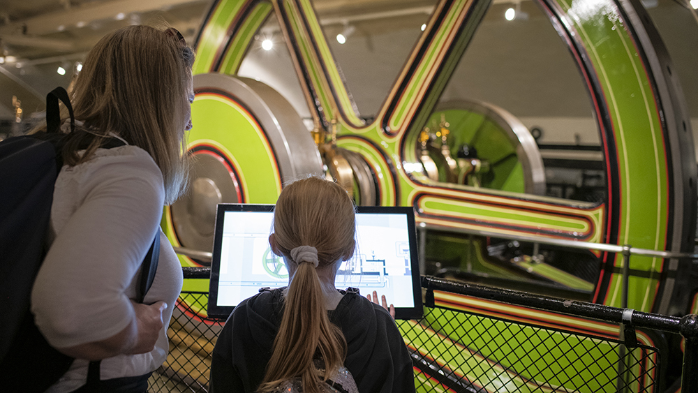 Mum and daughter looking at the Victorian engines of Tower Bridge