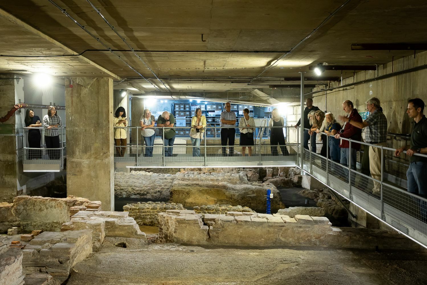 A group of people centred around the remains of the Billingsgate Roman House and Baths