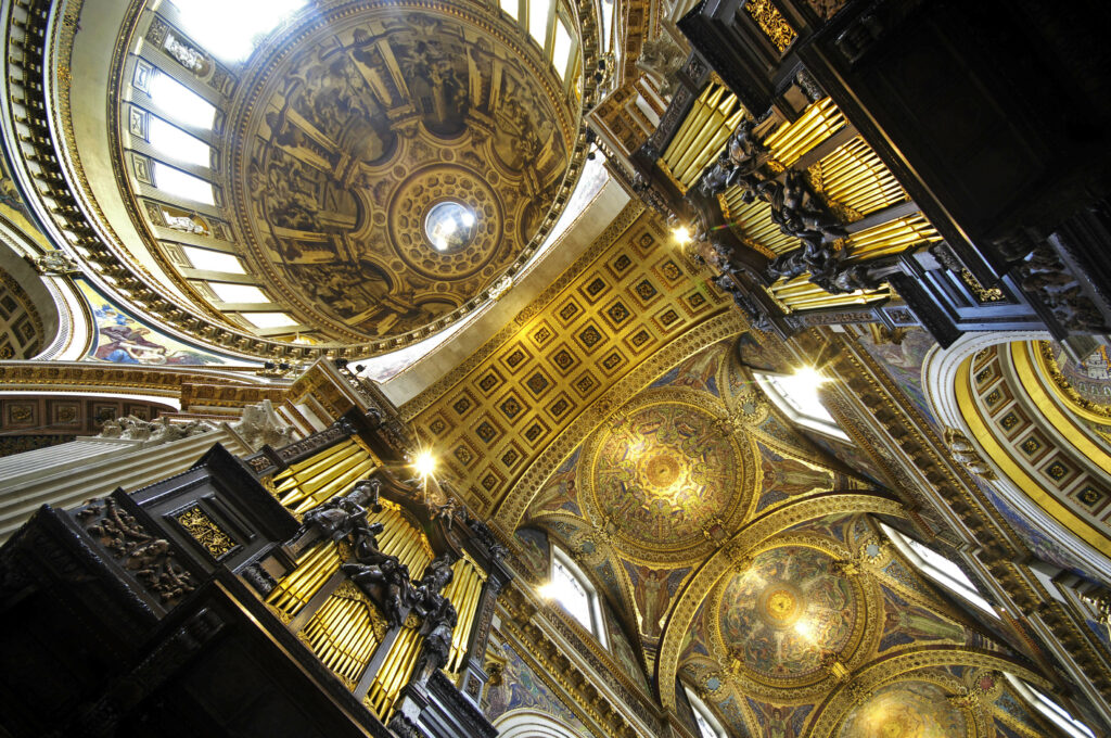 Interior view of St. Paul's Cathedral, showcasing the ornate golden ceilings and detailed architectural designs.