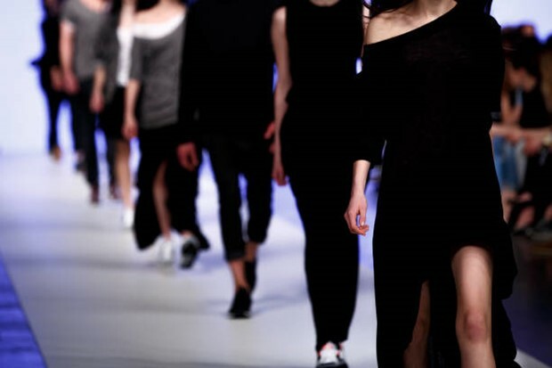 Models walking on a fashion show runway.