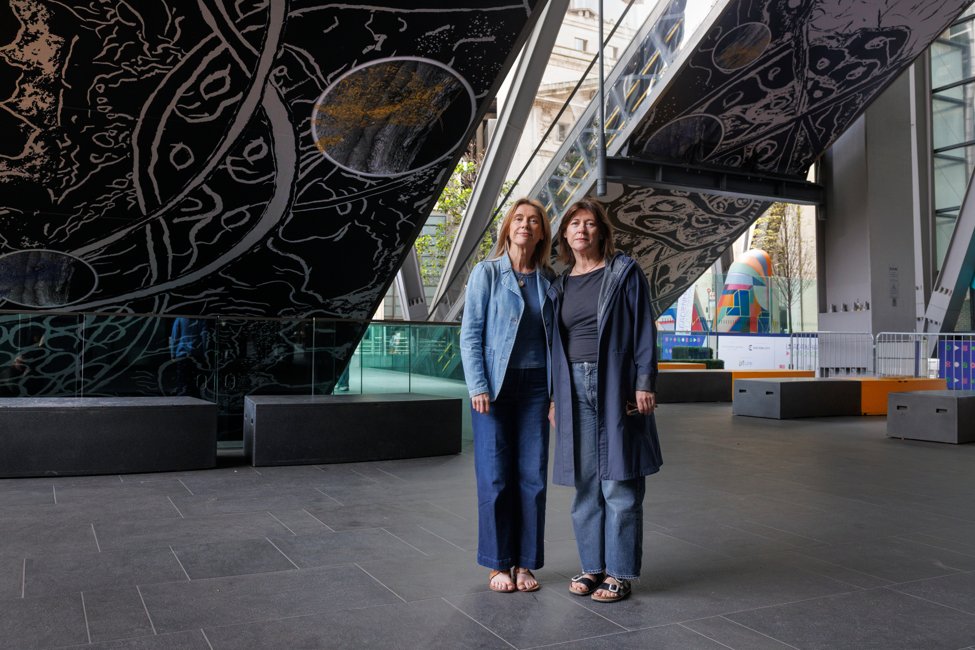 Artists Jane and Louise Wilson standing under their artwork entitled Dendrophiles at the Leadenhall Building, City of London.