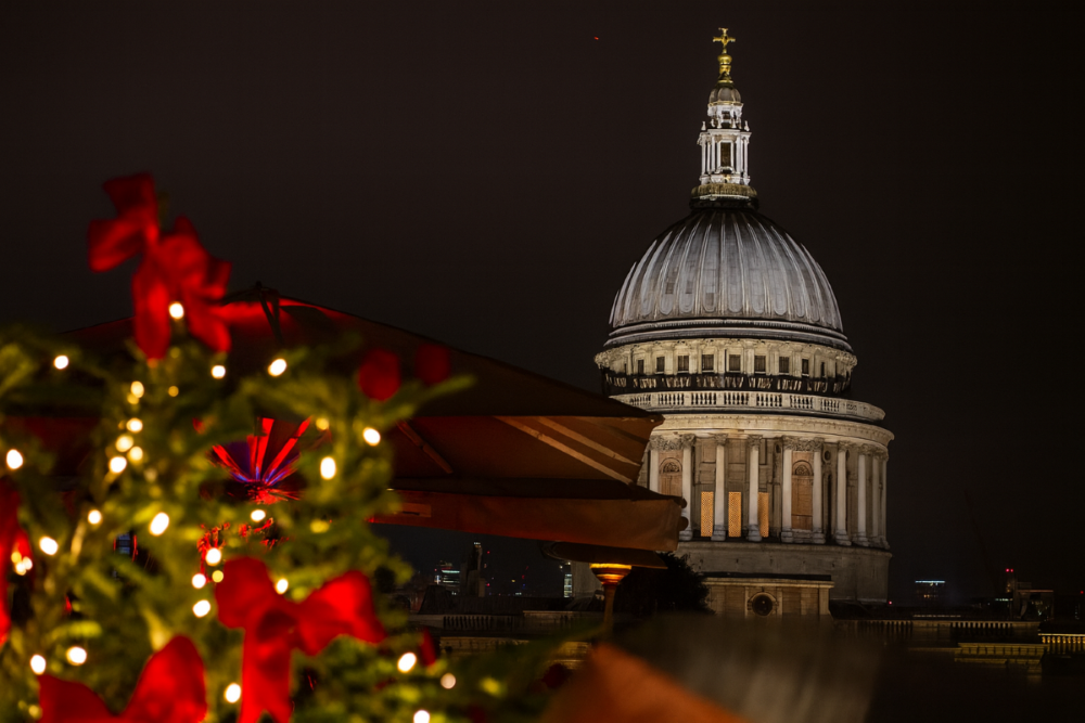 A night view over St Paul's Cathedral from a London rooftop, with Christmas lights