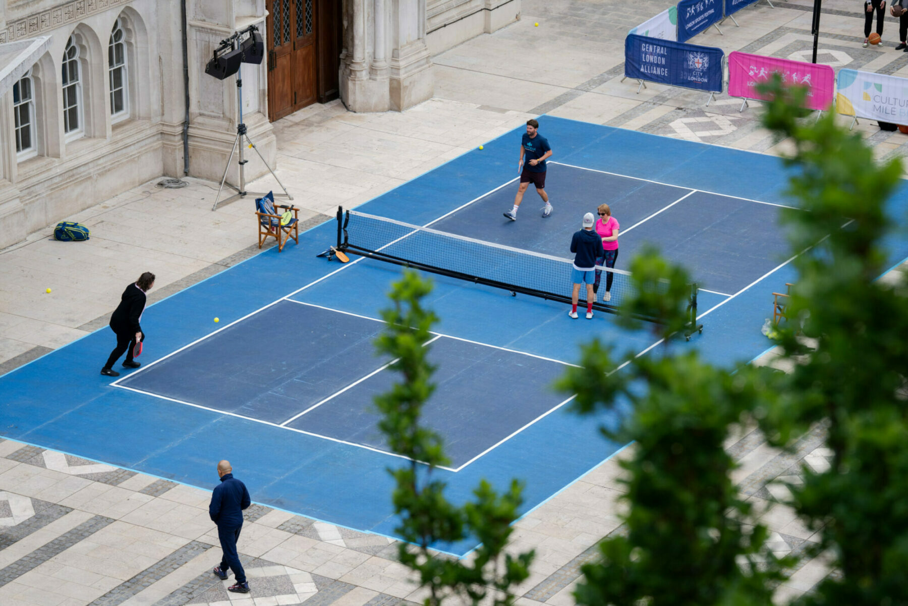 A high angle shot of a pickleball court with players on
