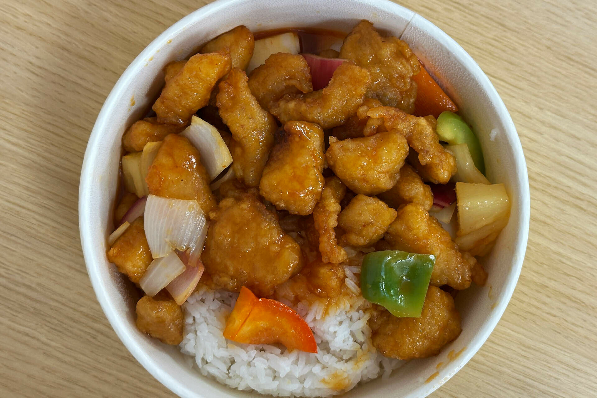 Top level shot of a round bowl of sweet & Sour chicken
